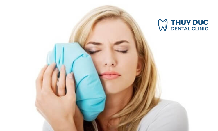 Chườm đá vào vùng má đang bị sưng 1